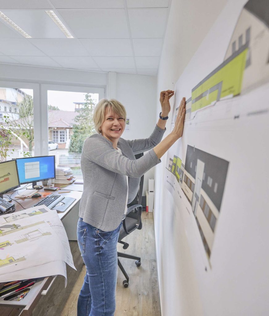 Frau präsentiert Architekturpläne im Büro
