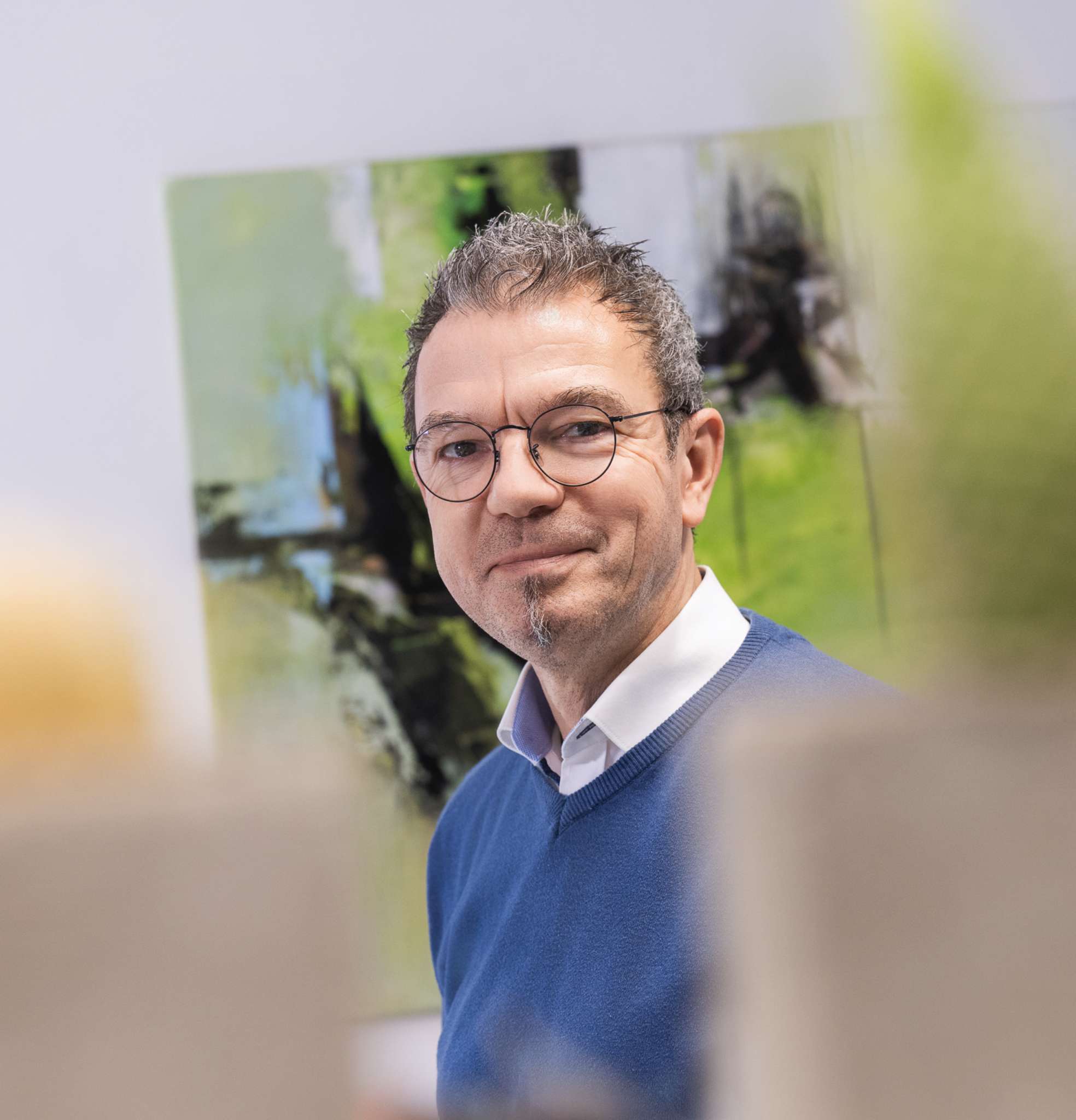 Mann lächelt vor abstraktem Gemälde