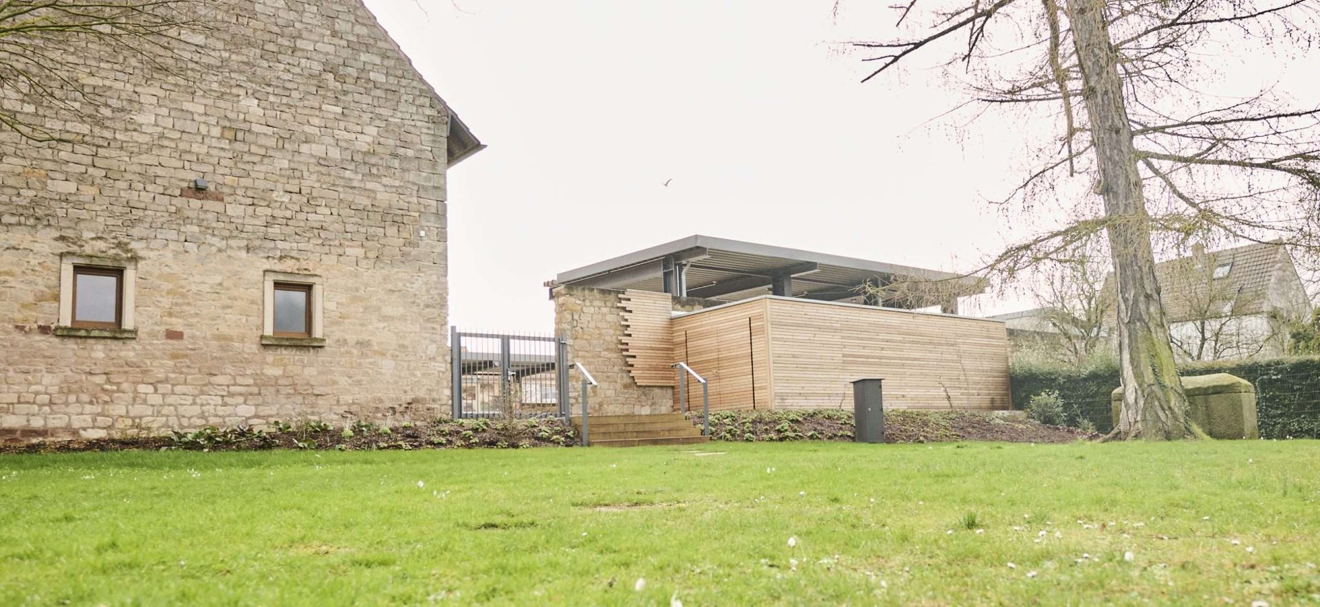Moderner Anbau neben altem Steinhaus