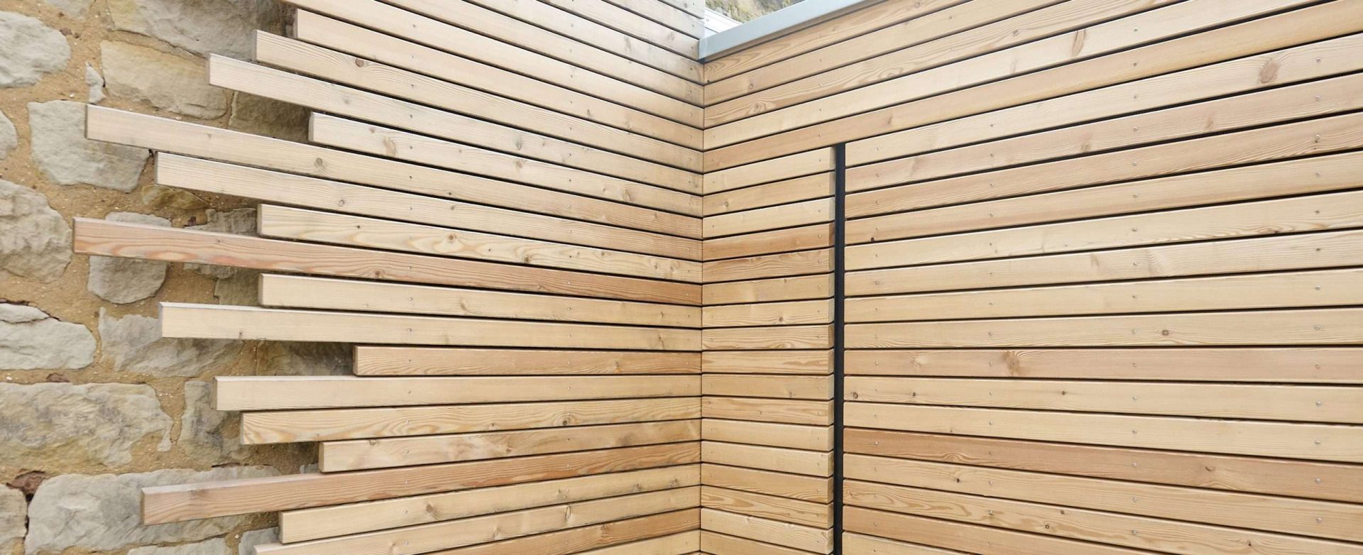 Moderne Holzfassade mit Steinsäule